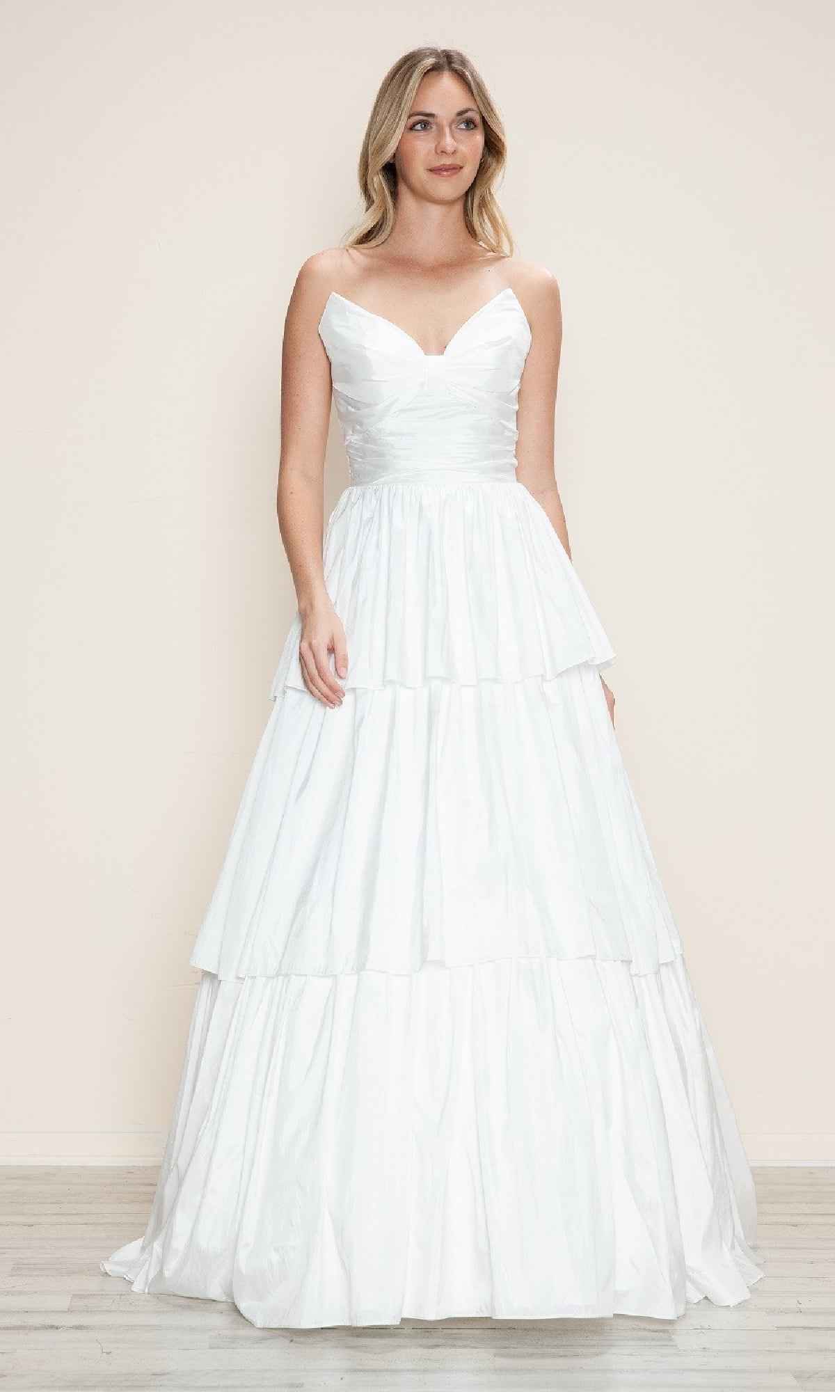 A woman models the Poly USA 9694 long prom dress, featuring a strapless fitted bodice and full tiered A-line skirt, against a plain light background.